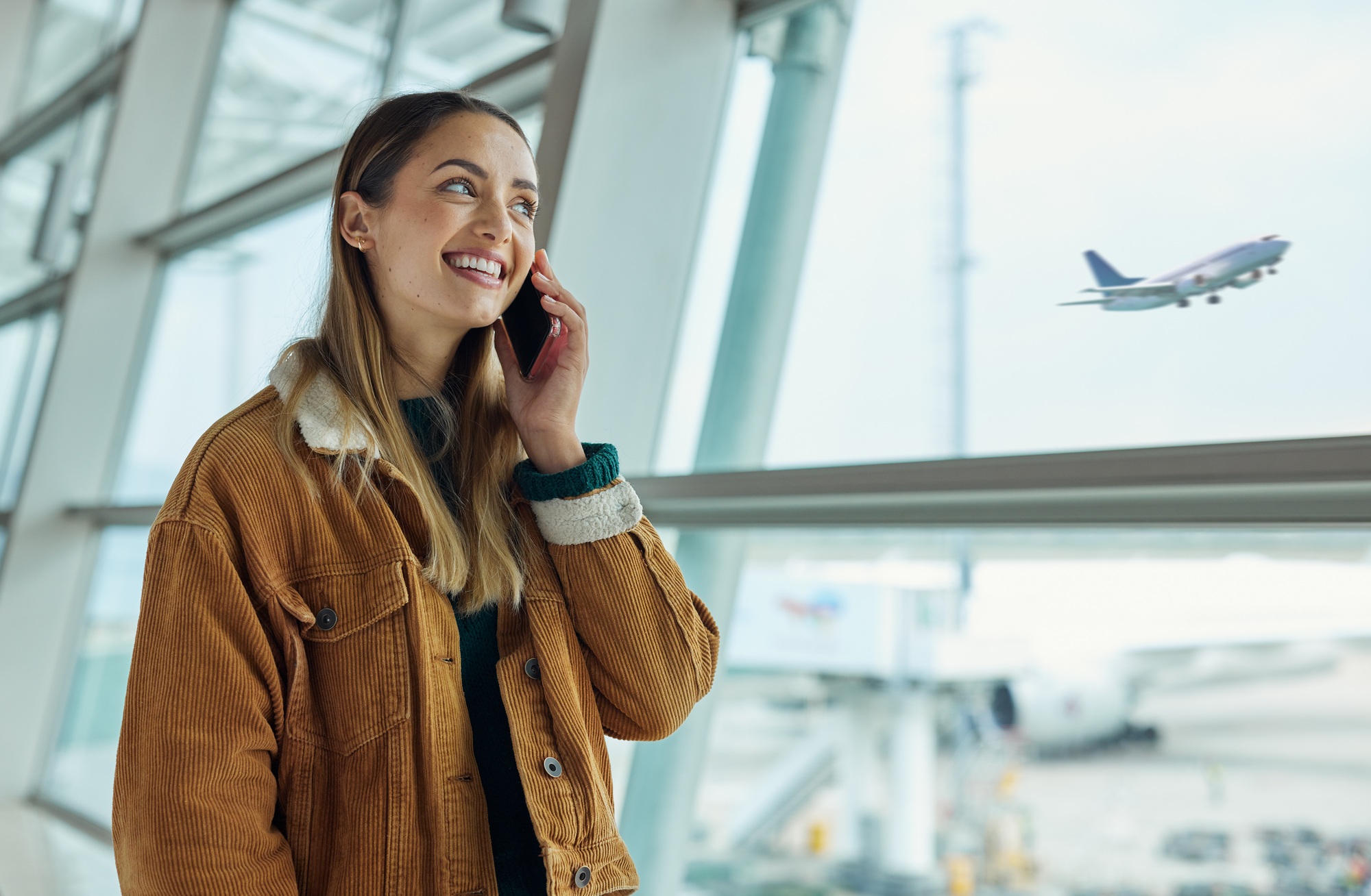 Phone call, travel and woman talking at airport, chatting or speaking to contact in lobby. Communic
